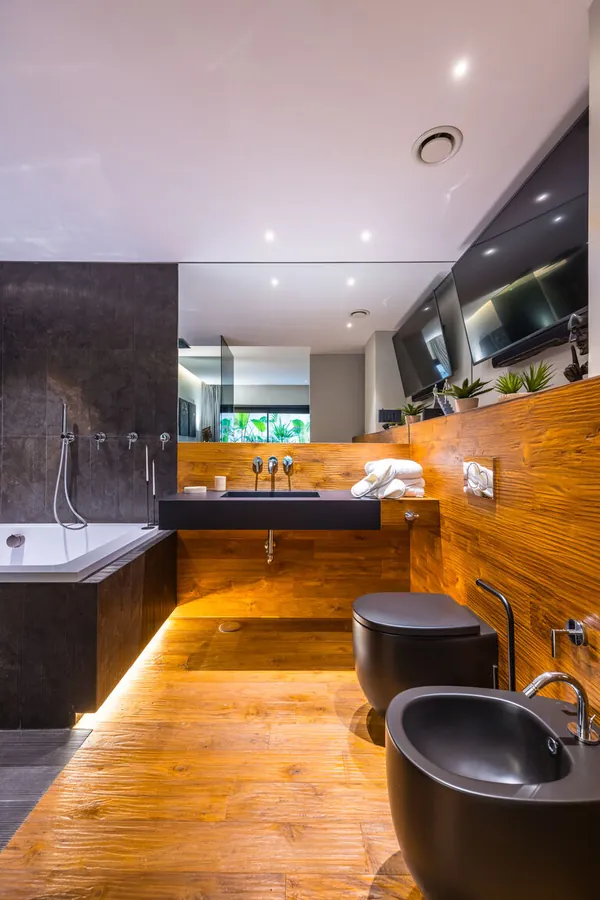 Bagno padronale Santopaolo 1 con vasca, doccia separata, rivestimento in legno e pietra naturale scura