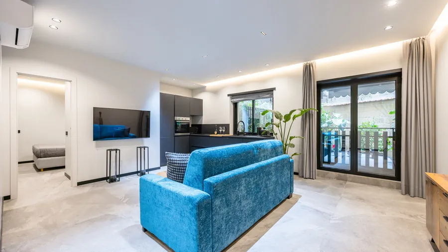 Zona living Santopaolo 4 con cucina antracite, smart TV e porta finestra sul patio